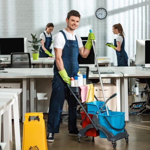 stock-photo-cheerful-cleaner-moving-cart-cleaning-supplies-multicultural-colleagues