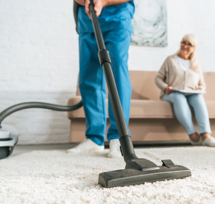 stock-photo-cropped-shot-man-using-vacuum-cleaner-while-senior-woman-sitting